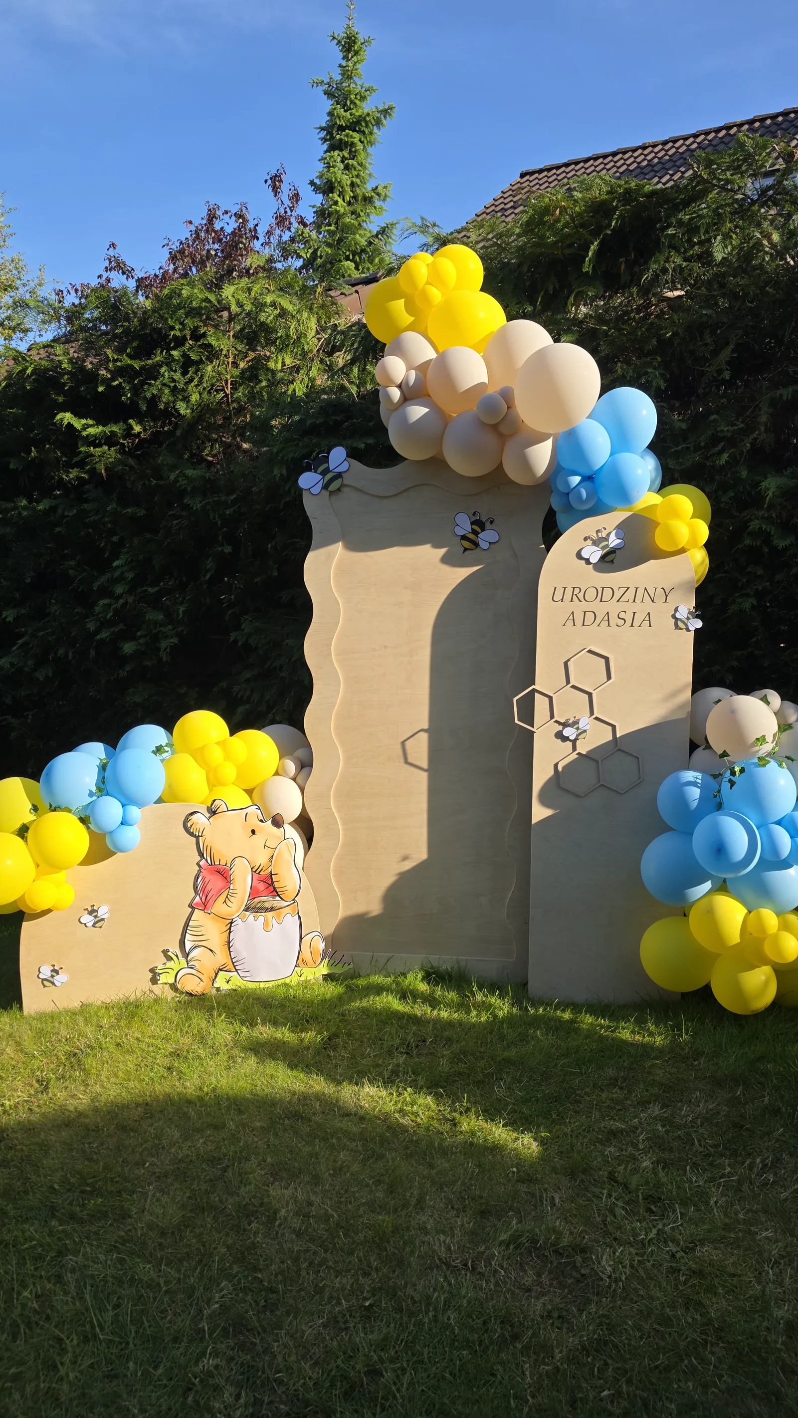 Ścianki na urodziny Adasia w ogrodzie z misiem, balony żółte, błękitne i beżowe